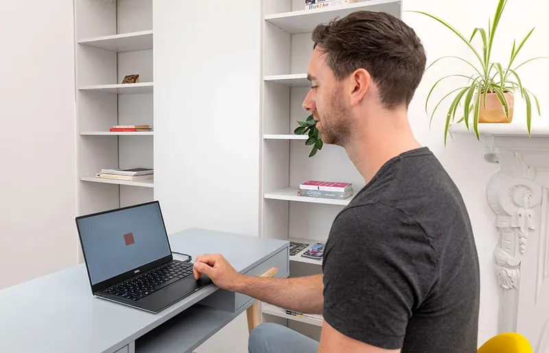 A man taking the QbCheck test on a laptop at his desk